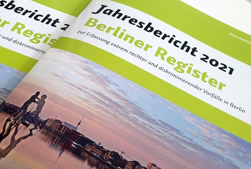 Das Cover des Jahresberichts 2021 der Berliner Register. Das Layout ist in den Farben grün und weiß. In der unteren Hälfte ein Foto mit Sicht auf die Spree in der Abenddämmerung und die Molecule Men.